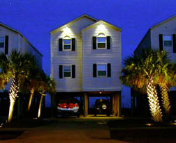 House and twlight and lighted palm trees.